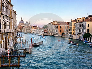 A beautiful evening view of the Grand Canal in Venice, Italy with water taxis and gondolas past by and the Santa Maria Della Salut