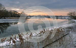 A beautiful evening on a winter river, a calm river against the sunset