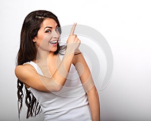 Beautiful excited casual woman pointing the finger up with tooth