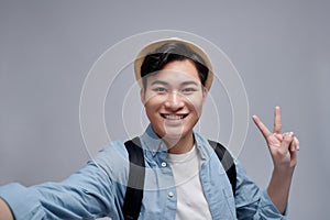 Beautiful excited young man makes self portrait v sign smiling