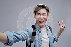 Beautiful excited young man makes self portrait v sign smiling