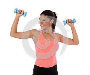 Beautiful and exotic hispanic woman holding hand weights training in fitness concept