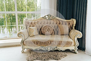 Beautiful expensive beige sofa against a white wall in an empty room