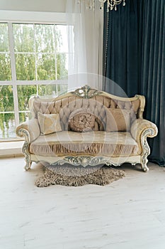 Beautiful expensive beige sofa against a white wall in an empty room