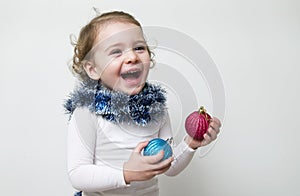 Beautiful expressive happy cute laughing smiling baby infant face with christmas toys