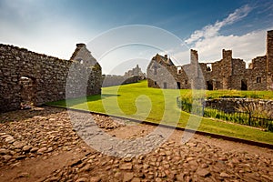 Beautiful Exterior of Dunnottar Castle with blue sky and green grass, near Stonehaven, Aberdeenshire, Scotland, UK