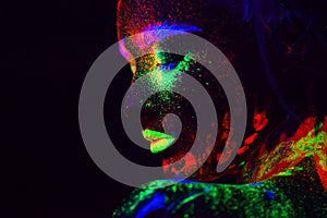 Beautiful extraterrestrial model woman with blue heair and green lips in neon light. It is portrait of beautiful model