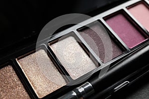 Beautiful eye shadow palette with brush on dark grey table
