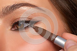 Beautiful eye of woman with amazing make up. Girl is applying eyeliner on eyes