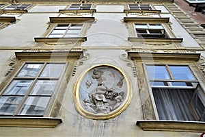 Beautiful facade of a historic Vienna palace, with oval, between two columns of three windows, depicting a woman, perhaps the Mado