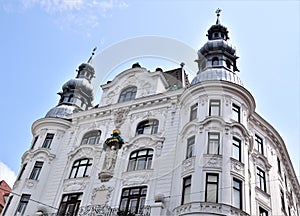 Beautiful facade of a historic white building in Vienna, with a central statue and two towers on either side.