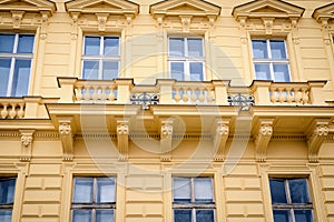 Beautiful facade of the old yellow house. Fragment, details. Prague, Czech Republic