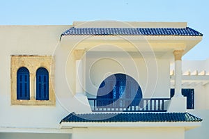 Beautiful facade of white Arab house with blue windows in Tunisia