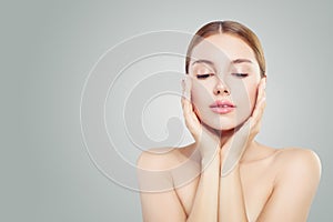 Beautiful face. Pretty woman holding her face in her hands. Facial treatment, face lifting, anti aging and skin care concept