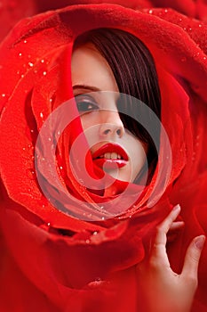 Beautiful face in red roses petals