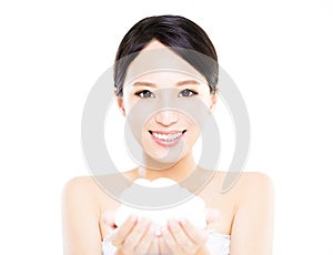 Beautiful face of young smiling woman showing cream on hand