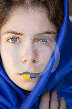 Beautiful face of a young Ukrainian woman with painted yellow-blue lips close-up