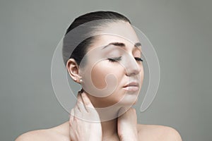 Beautiful Face of Young Woman with Clean Fresh Skin close up isolated on gray.