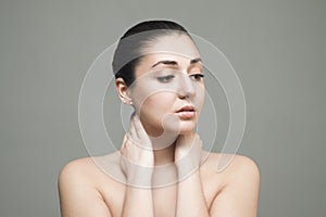 Beautiful Face of Young Woman with Clean Fresh Skin close up isolated on gray.