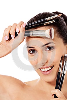 Beautiful face of young woman with make up brush.