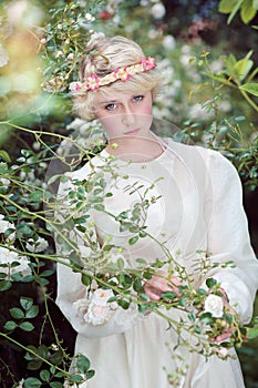 Beautiful fairy girl in roses garden