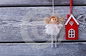 Beautiful fairy in a white dress and red house on a wooden fence