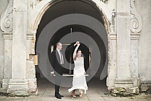 Beautiful fairytale newlywed couple hugging near old medieval castle