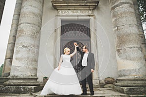 Beautiful fairytale newlywed couple hugging near old medieval castle