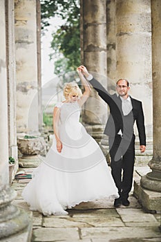 Beautiful fairytale newlywed couple hugging near old medieval castle