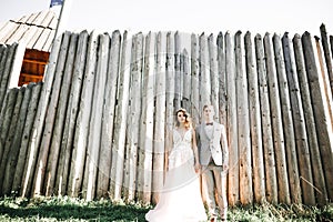 Beautiful fairytale newlywed couple hugging near old medieval castle