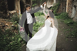 Beautiful fairytale newlywed couple hugging near old medieval castle