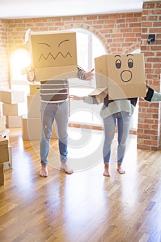 Beautiful famiily with kid playing with cardboard fanny boxes at new home