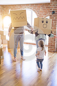 Beautiful famiily with kid playing with cardboard fanny boxes at new home