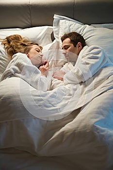 Beautiful family couple sleeping sweet and sound, lying in bed