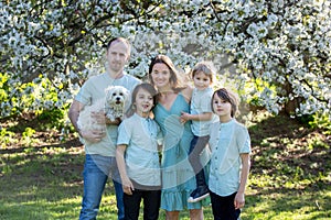 Beautiful family with kids, mom, dad, three boys and a dog, playing in the park