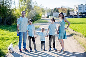 Beautiful family with kids, mom, dad, three boys and a dog, playing in the park