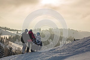 Beautiful family with kids, skiing in a scenery area in Austrian Alps on sunset, enjoying the view