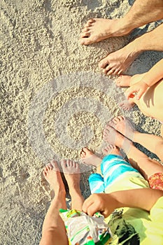 A beautiful family legs on the sand by the sea