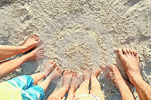 A beautiful family legs on the sand by the sea