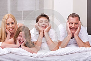 Beautiful family lying on bed smiling