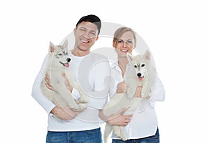 Beautiful family, a man and woman holding hands on the husky puppies, isolation