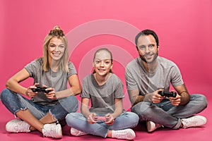 beautiful family playing video game with joysticks, isolated