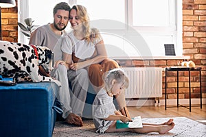 Beautiful family spend weekends with dog in cozy home environment