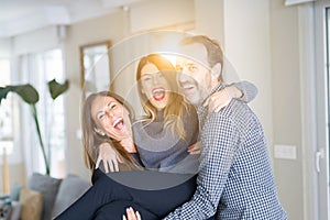 Beautiful family together. Mother, father and daughter smiling and hugging with love at home