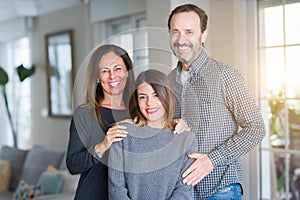 Beautiful family together. Mother, father and daughter smiling and hugging with love at home