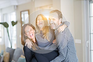 Beautiful family together. Mother, father and daughter smiling and hugging with love at home