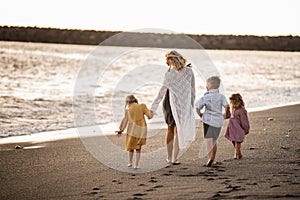 Beautiful family walking on the beach. Mother with kid spending time together on vacation. Full length