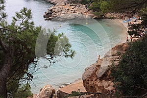 The beautiful and famous bay of cala saladeta of ibiza seen from above or rocky inlet between the rocks and the vegetation of the photo