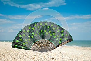 Beautiful fan sand close-up on the background of the sea and sky, clouds veil still life summer sun