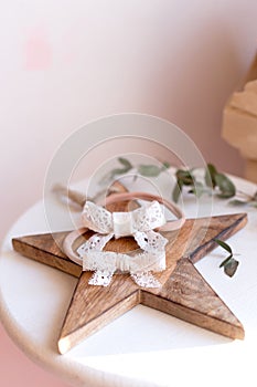 Beautiful fashion accessory for baby girls. Handmade accessories lace and stars on elastic band on white and brown background.